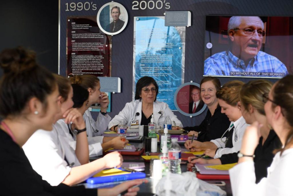 Nursing students gathered around table with books