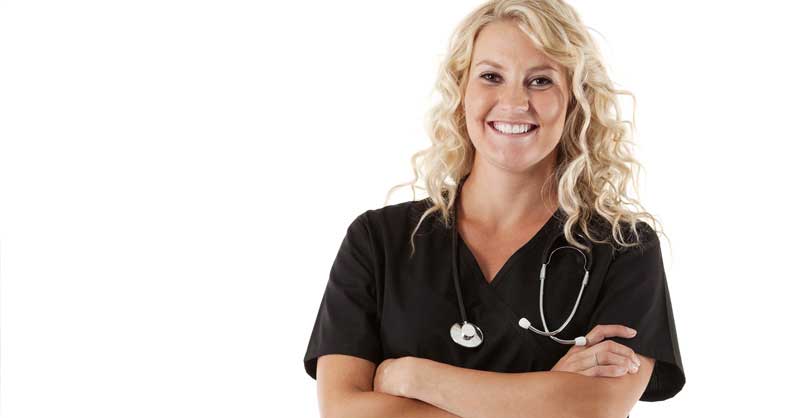 Smiling nurse standing with arms crossed