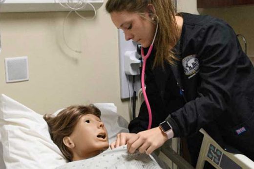nursing student working with sim manikin