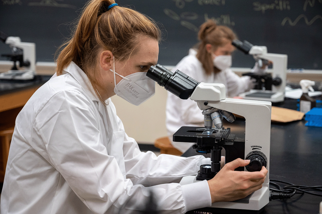 nursing students looking through microscope