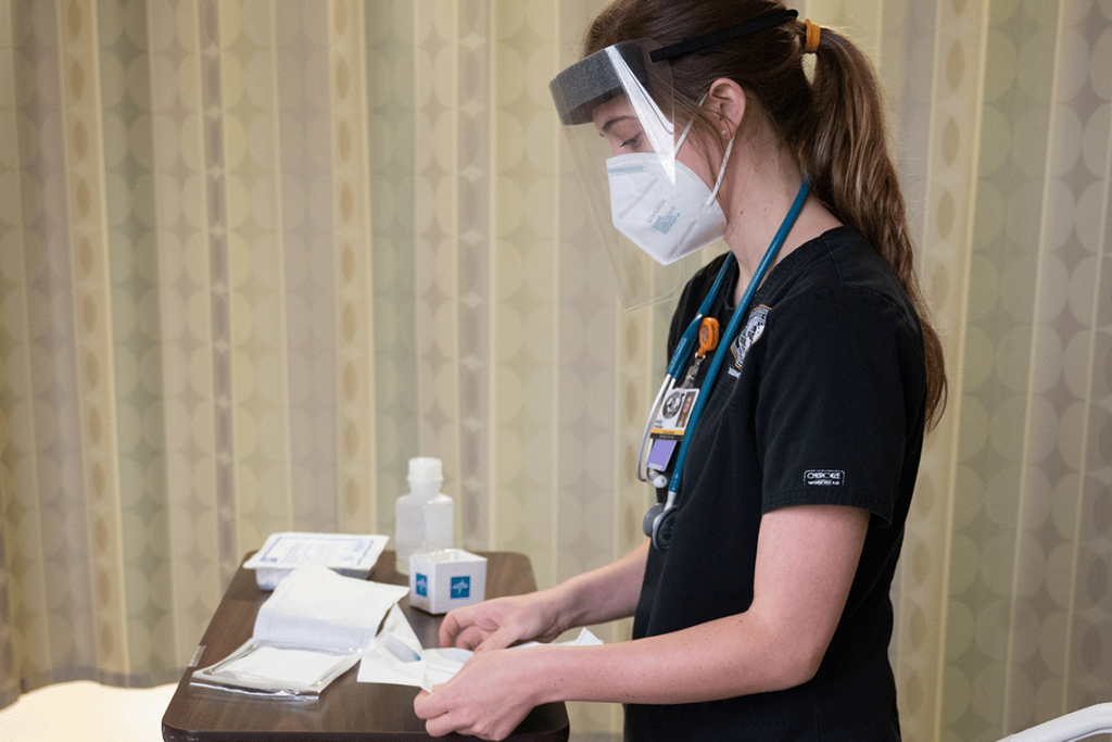 Nursing student with mask opening up gauze