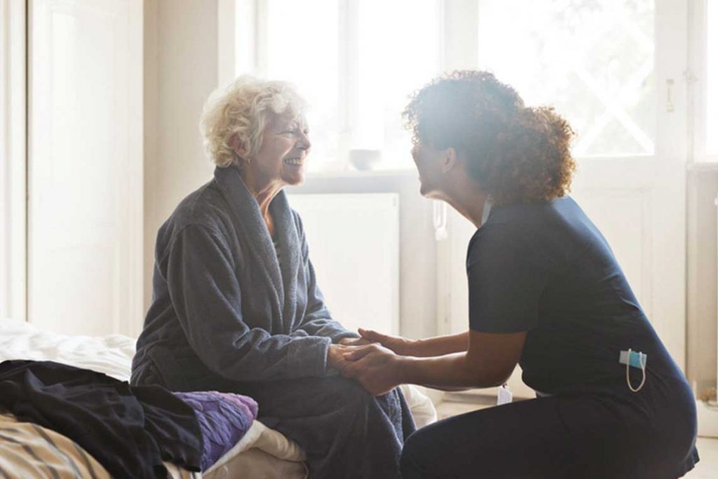 nurse holding hands with elderly patient