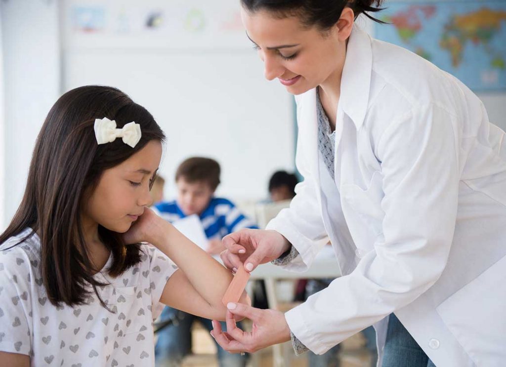 nurse helping child with a band-aid