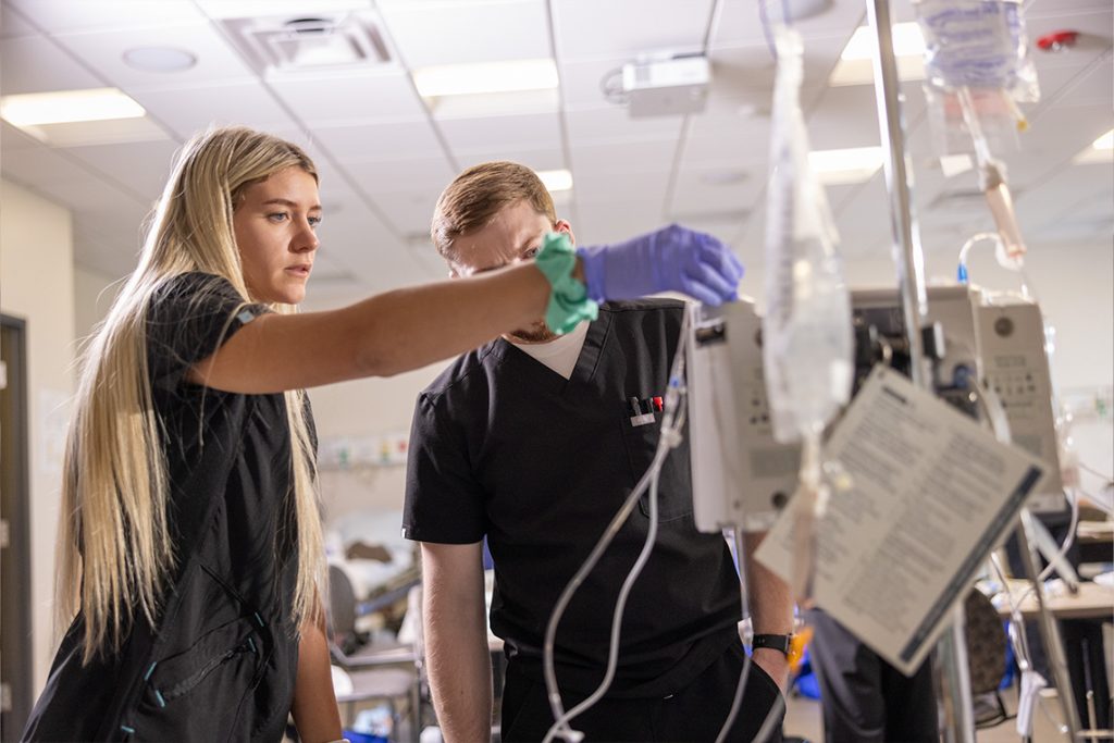  two nursing students holding bag of fluids