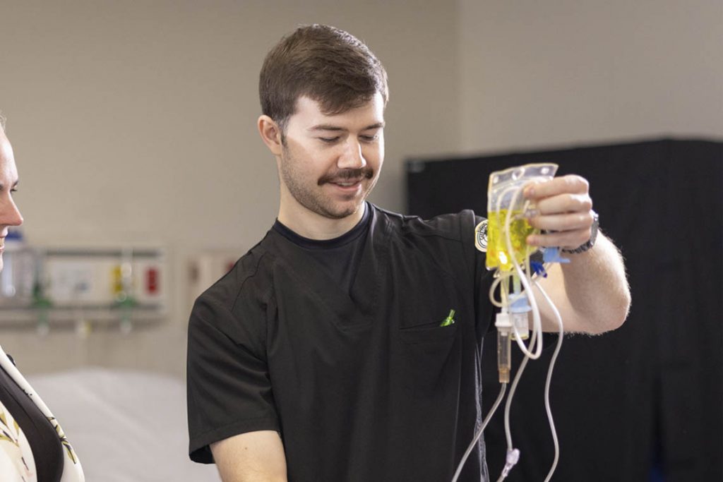 nursing student holding IV bag