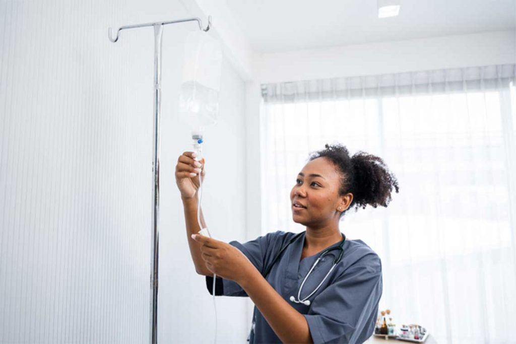 nurse setting up IV bag